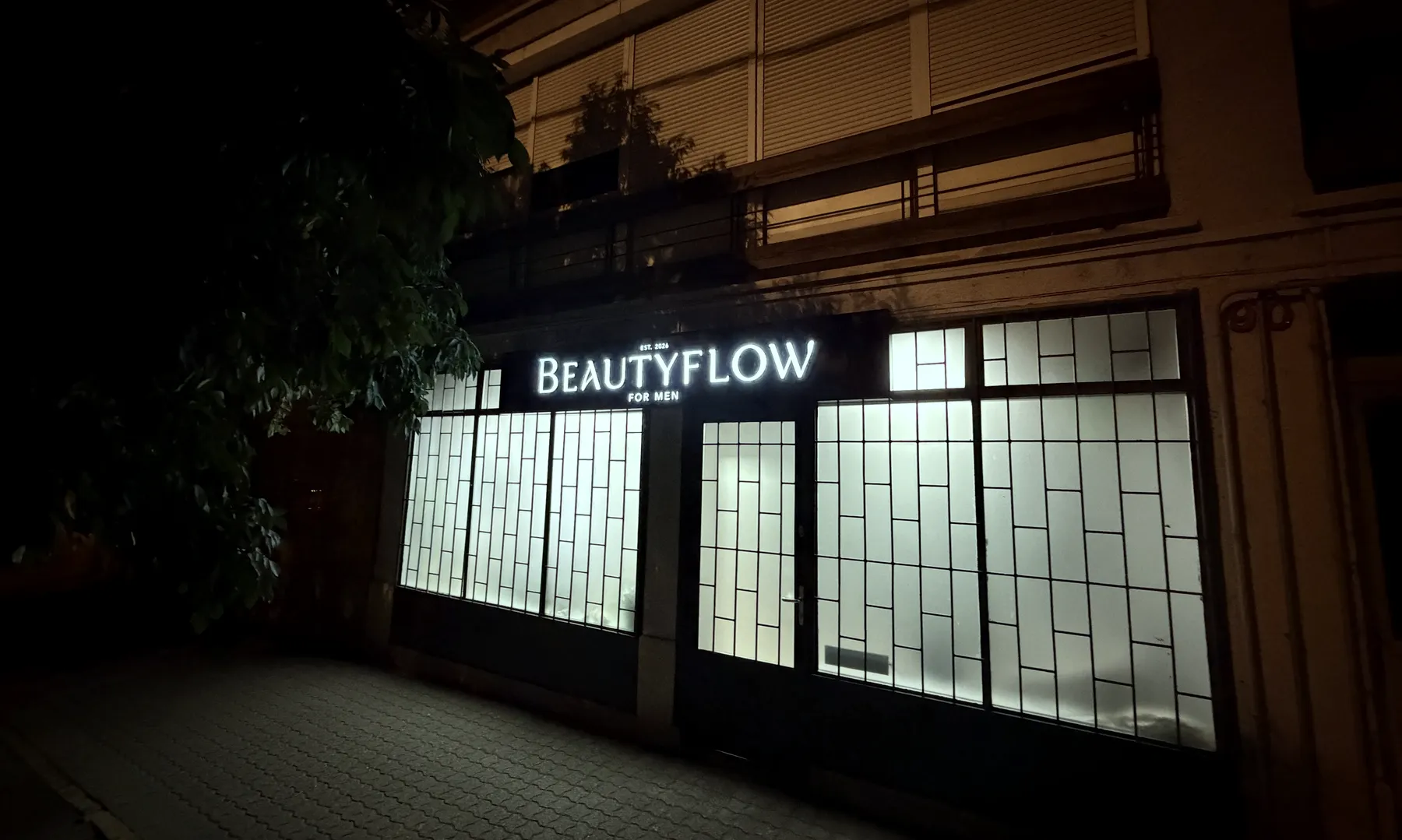 A Beautyflow for Men szalon kivilágított bejárata esténként, Budapest XIII. kerület, Reitter Ferenc utca 90.