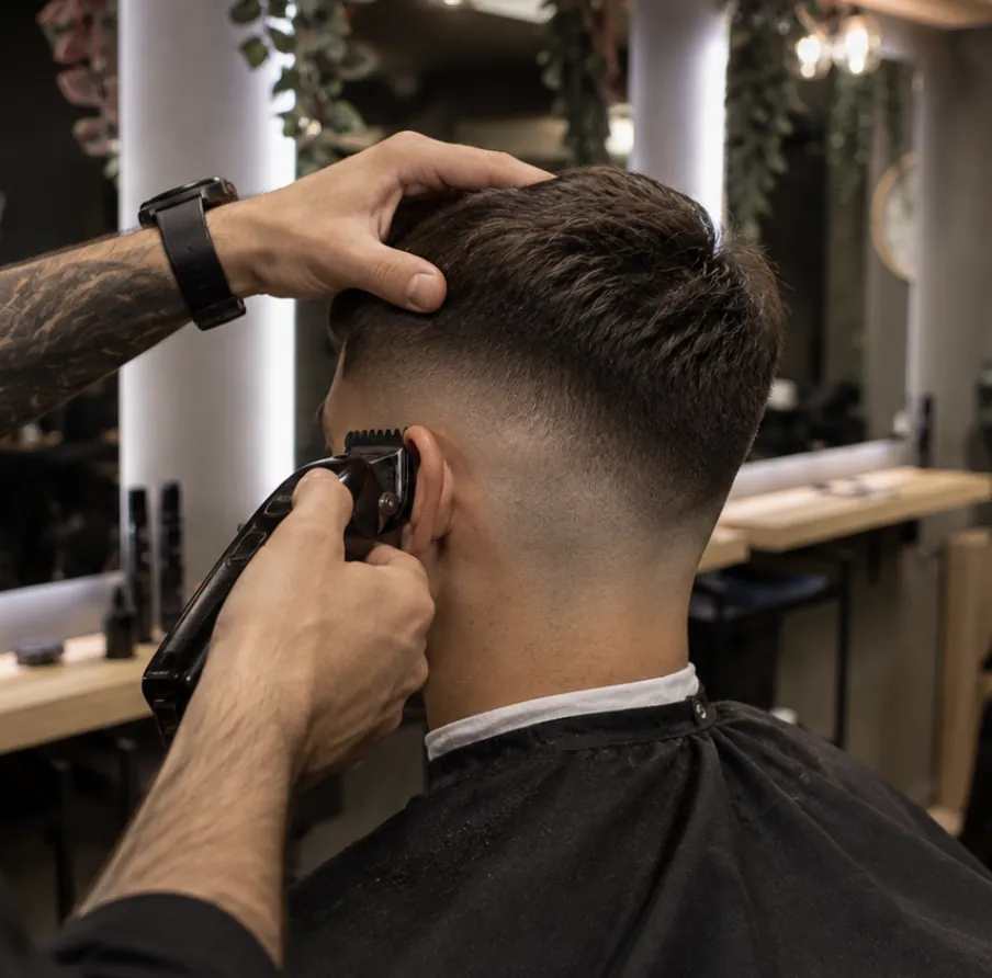 Fade hajvágás hajvágógéppel a Beautyflow for Men barber részlegén, a háttérben a szalon tükreivel